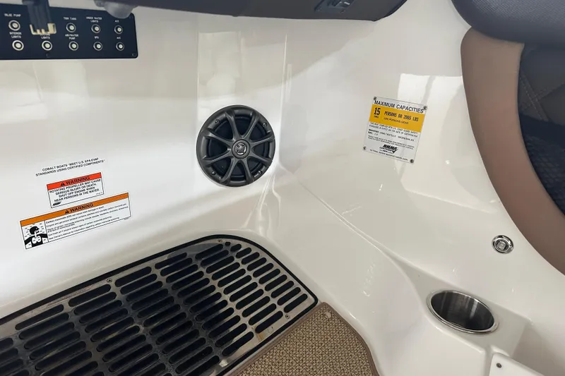 Slide: The Image of Interior of 2012 Cobalt A25 boat showing speaker, warning labels, and capacity information. - 22