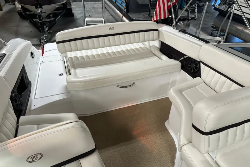 Slide: The Image of Interior of a 2012 Cobalt A25 boat with white leather seating and carpeted floor. - 29