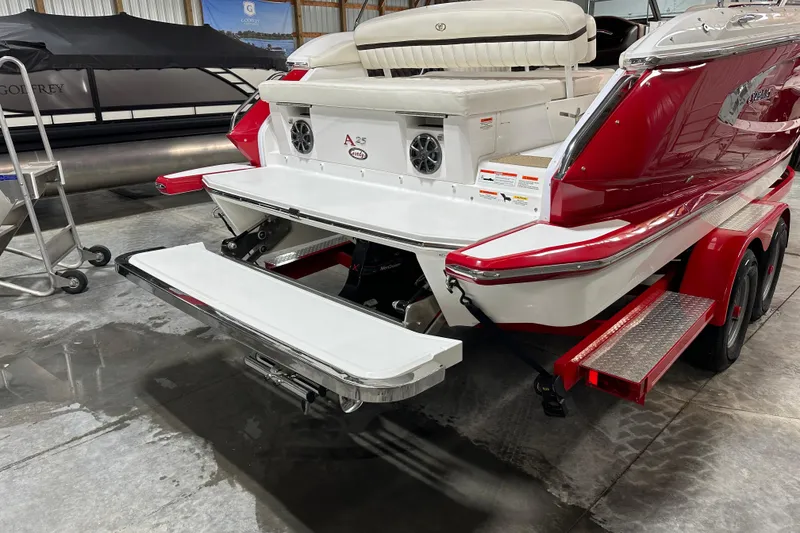 Slide: The Image of 2012 Cobalt A25 boat with red and white exterior, featuring a swim platform in a garage. - 6