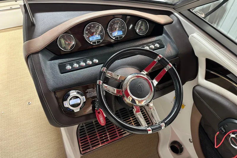 Slide: The Image of Steering wheel and dashboard of 2012 Cobalt A25 boat, featuring gauges and controls. - 8