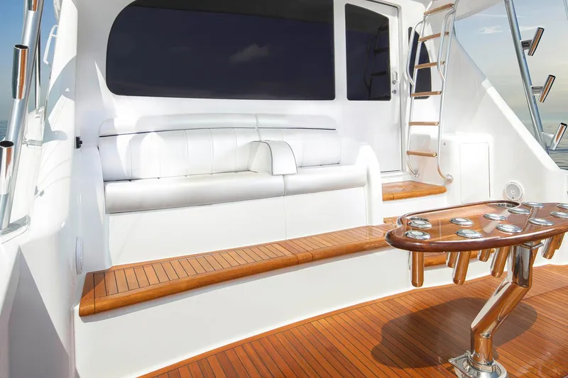 Slide: The Image of 2026 Viking 58 Convertible yacht deck with seating and ladder, featuring sleek wood finishes. - 10