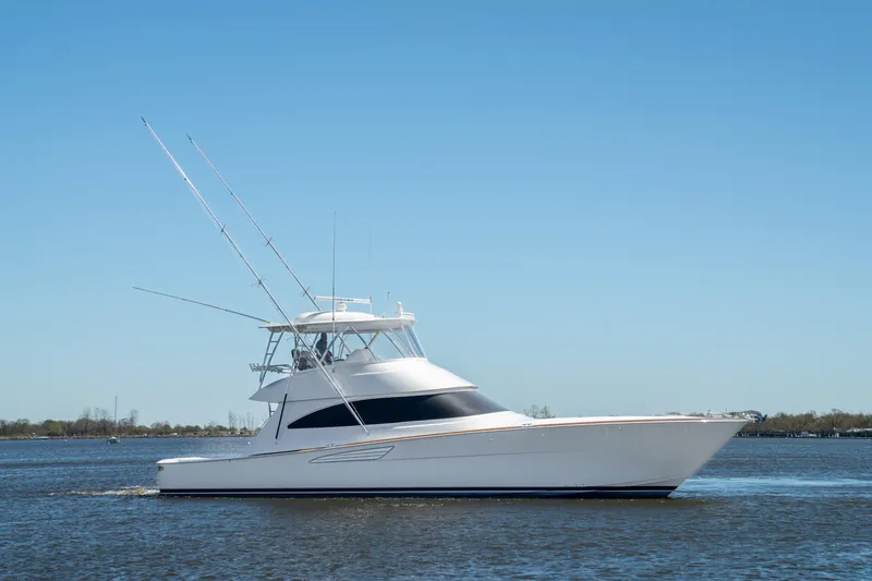 Slide: The Image of 2024 Viking 58 Convertible yacht cruising on calm waters under clear blue sky. - 2