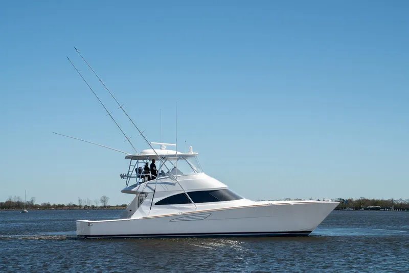 Slide: The Image of 2024 Viking 58 Convertible yacht cruising on open water under clear blue sky. - 3
