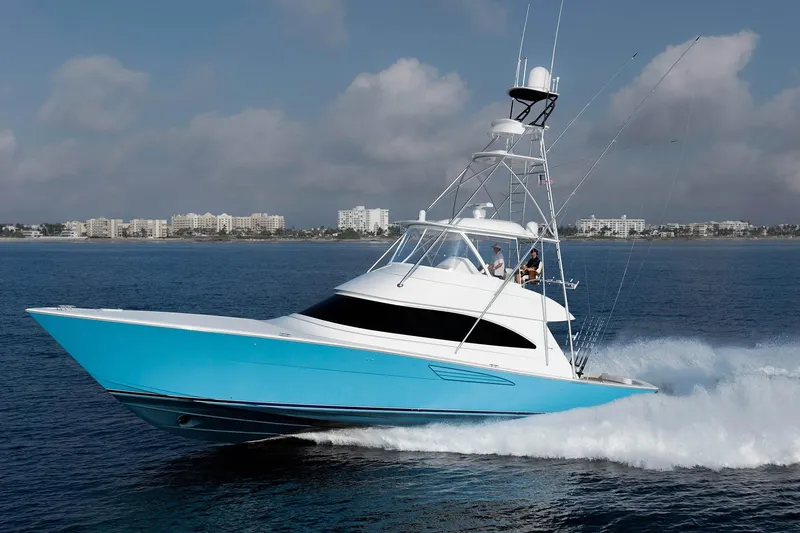Slide: The Image of 2026 Viking 58 Convertible yacht cruising on open water, cityscape in background. - 4