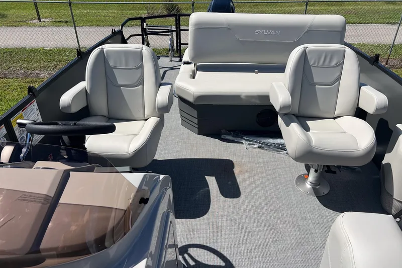 Slide: The Image of 2026 Sylvan Mirage 820 CLZ DH boat interior with white seating and steering wheel. - 9