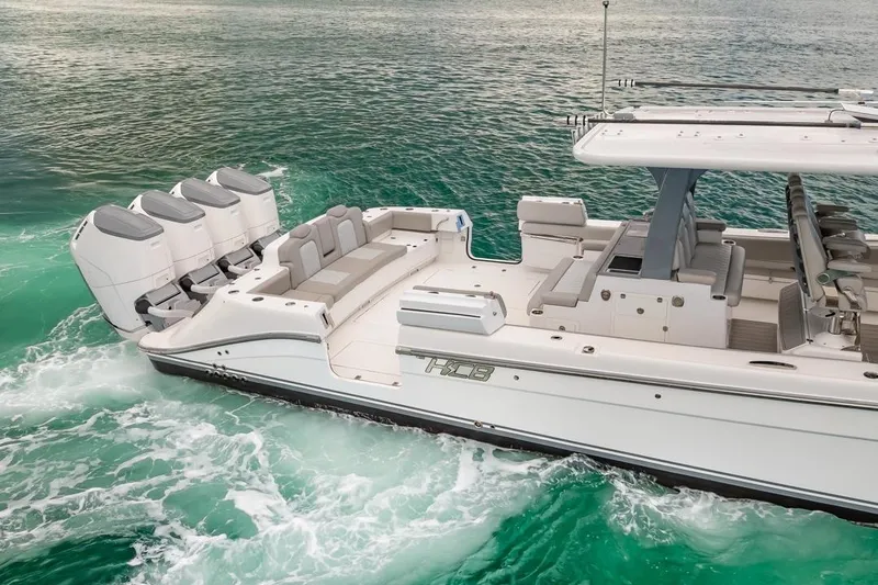 Slide: The Image of 2023 HCB 53 Sueños boat cruising on turquoise water, featuring multiple outboard engines. - 15