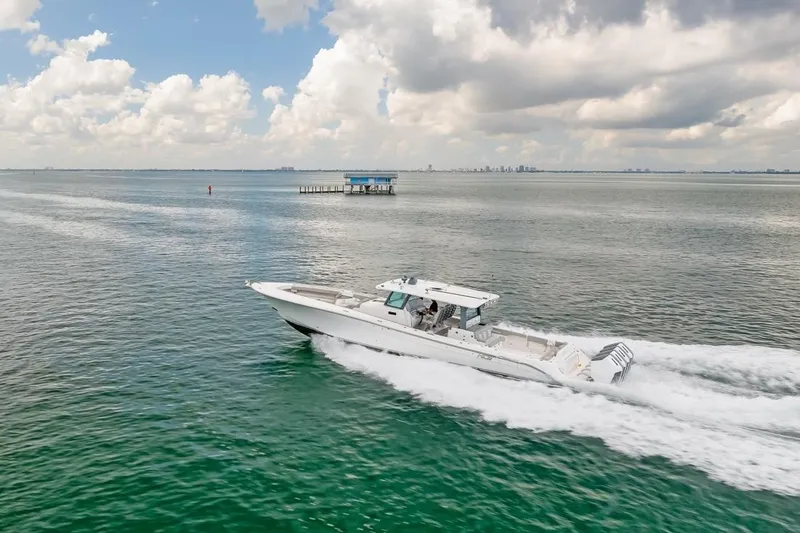 Slide: The Image of 2023 HCB 53 Sueños boat cruising on open water under cloudy sky. - 17