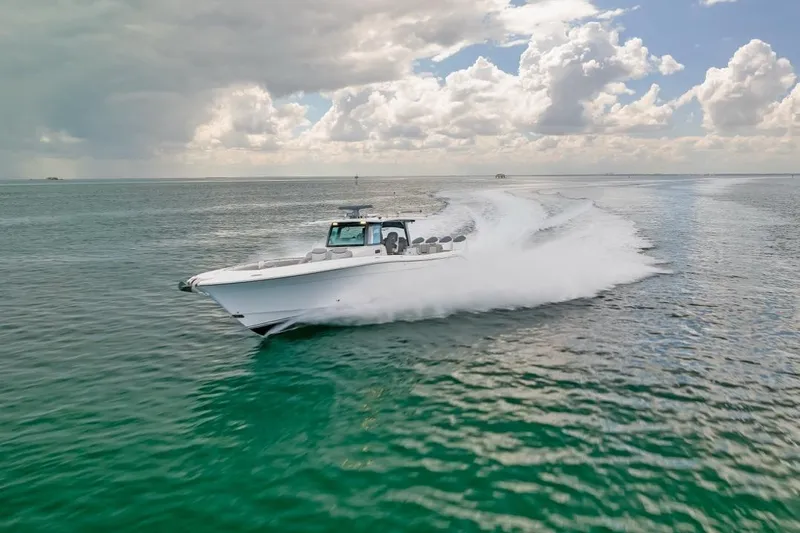 Slide: The Image of 2023 HCB 53 Sueños boat cruising on open water under cloudy sky. - 21