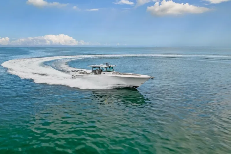 Slide: The Image of 2023 HCB 53 Sueños boat cruising on open water under blue sky. - 22