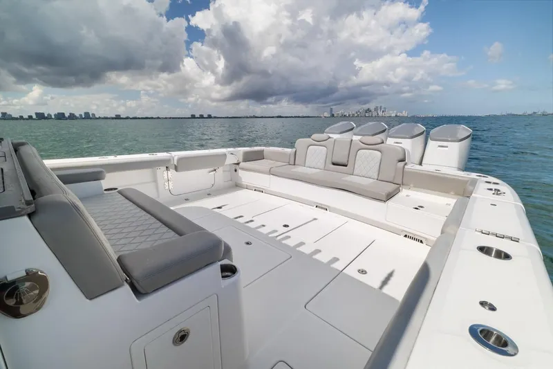 Slide: The Image of 2023 HCB 53 Sueños luxury boat with spacious seating, ocean view, and city skyline. - 27