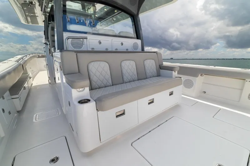 Slide: The Image of 2023 HCB 53 Sueños luxury boat interior with cushioned seating and ocean view. - 31