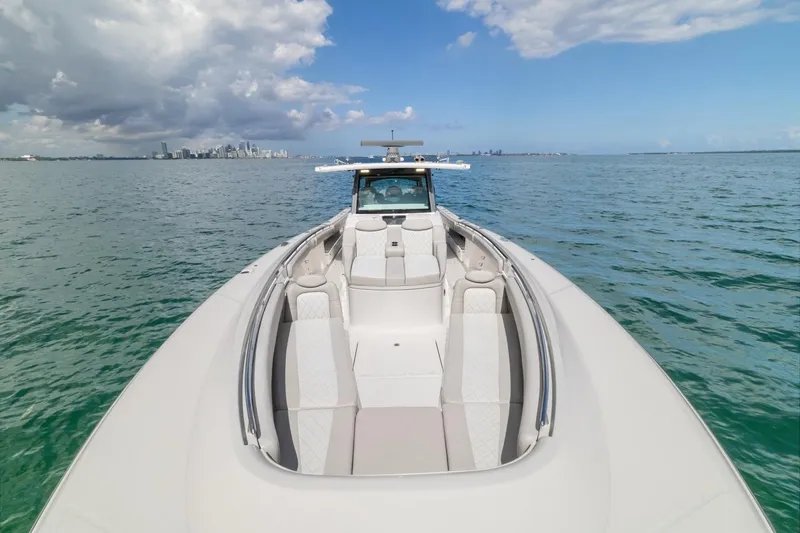 Slide: The Image of 2023 HCB 53 Sueños luxury boat on open water with city skyline. - 38