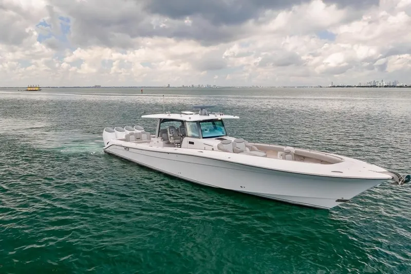 Slide: The Image of 2023 HCB 53 Sueños luxury boat cruising on open water under cloudy skies. - 5