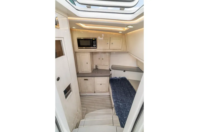 Slide: The Image of Interior of 2023 HCB 53 Sueños boat with kitchenette and seating area. - 54