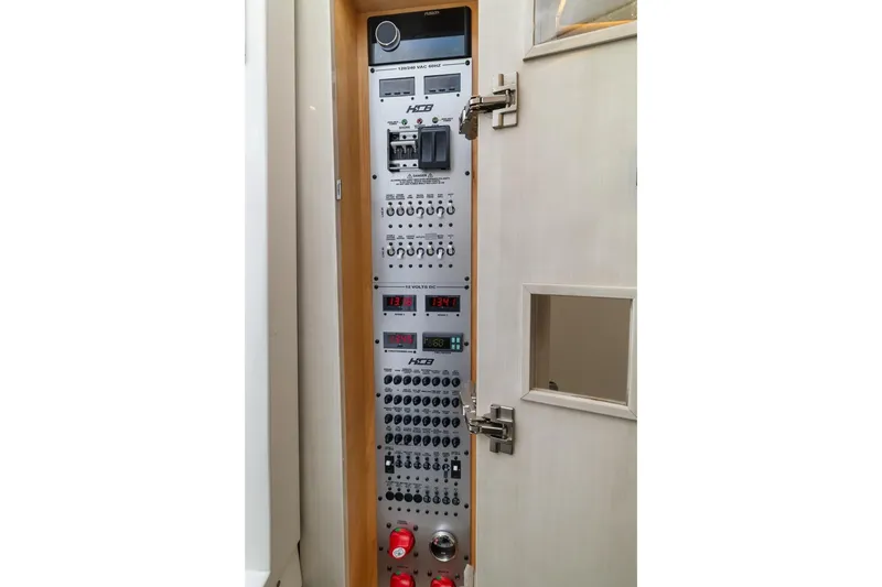 Slide: The Image of Electrical control panel inside 2023 HCB 53 Sueños boat, featuring various switches and displays. - 62