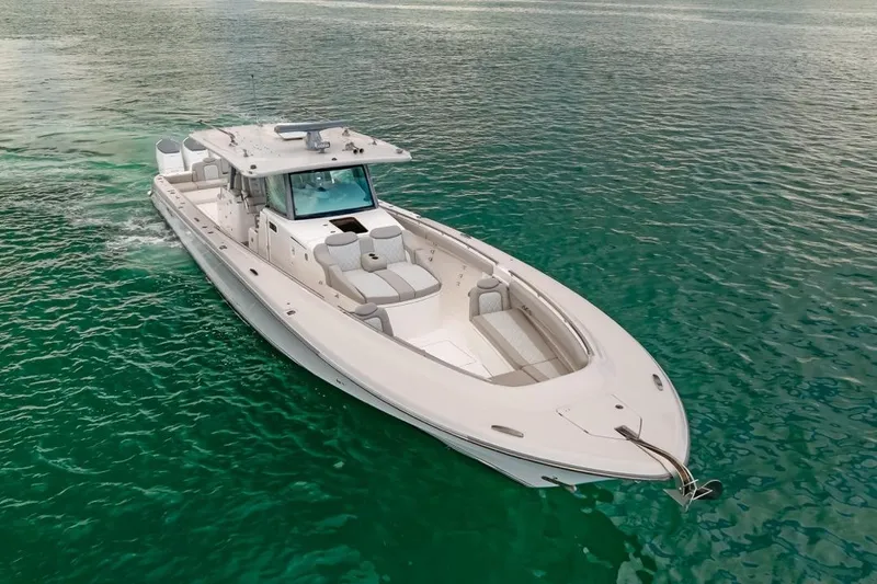 Slide: The Image of 2023 HCB 53 Sueños boat cruising on clear turquoise water. - 9