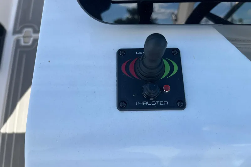 Slide: The Image of 2024 Regal LS9 Surf thruster control panel with joystick on boat deck. - 12