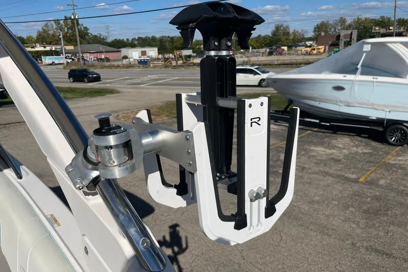 Slide: The Image of 2024 Regal LS9 Surf boat accessory, mounted on a metal rail, with a parked boat in the background. - 9