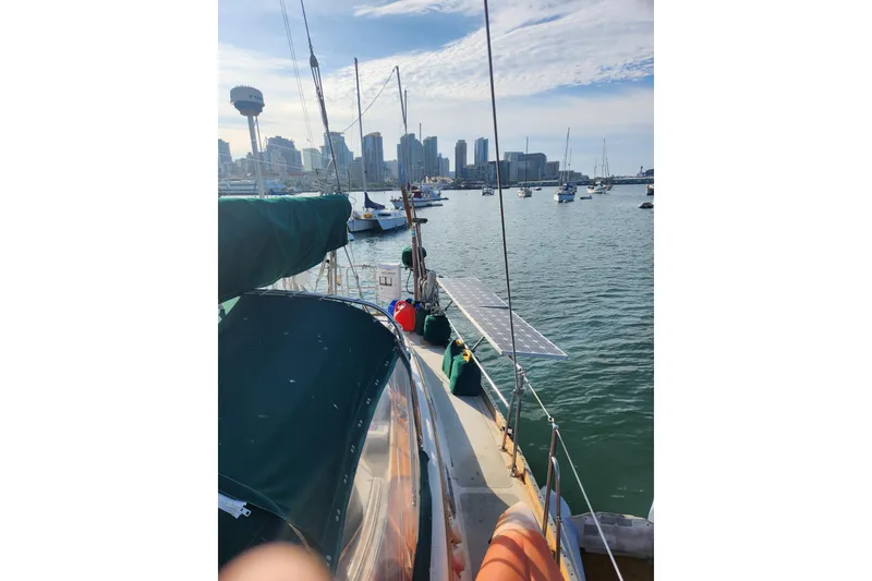 Slide: The Image of Sailboat "Guflstar Center Cockpit" 1981 docked in a marina with city skyline. - 13