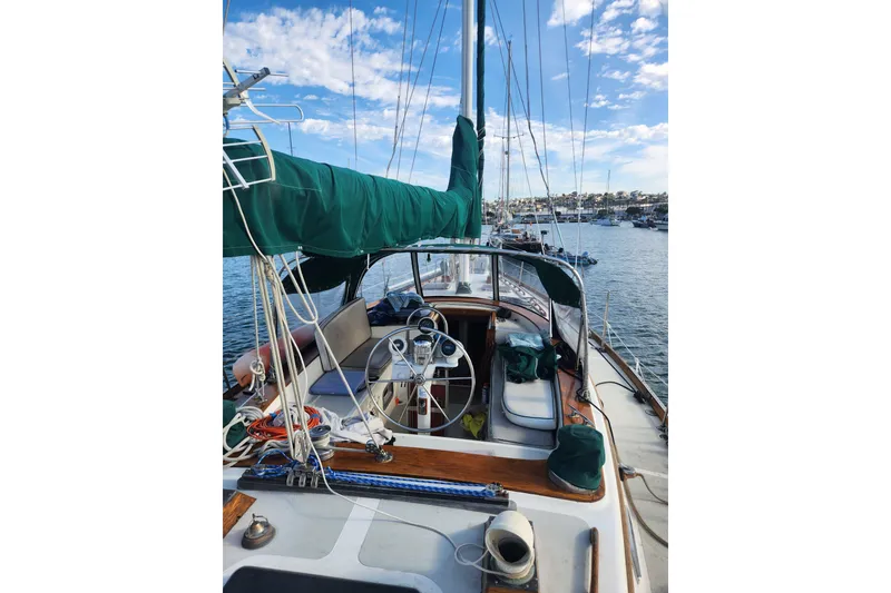 Slide: The Image of 1981 Guflstar Center Cockpit sailboat with green sail cover, docked in a marina. - 20
