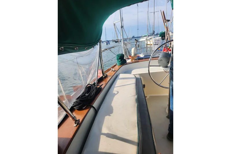 Slide: The Image of 1981 Guflstar Center Cockpit sailboat interior with steering wheel and seating, docked at marina. - 25