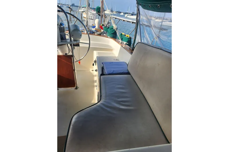 Slide: The Image of 1981 Guflstar Center Cockpit sailboat interior with cushioned seating and steering wheel. - 26