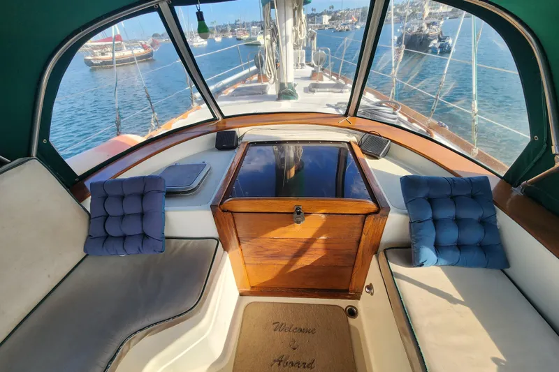 Slide: The Image of 1981 Guflstar Center Cockpit with cushions, overlooking serene harbor and anchored boats. - 27