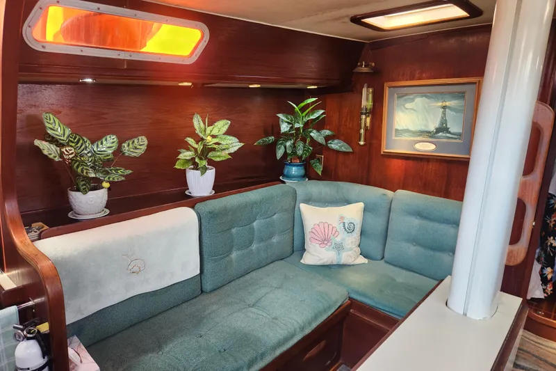 Slide: The Image of Cozy 1981 Guflstar Center Cockpit interior with plants, teal seating, and nautical decor. - 30