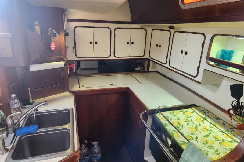 Slide: The Image of 1981 Guflstar Center Cockpit kitchen with dual sinks, white cabinets, and lemon-themed decor. - 35