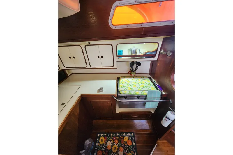 Slide: The Image of 1981 Guflstar Center Cockpit interior with kitchen area, featuring cabinets and a floral rug. - 39