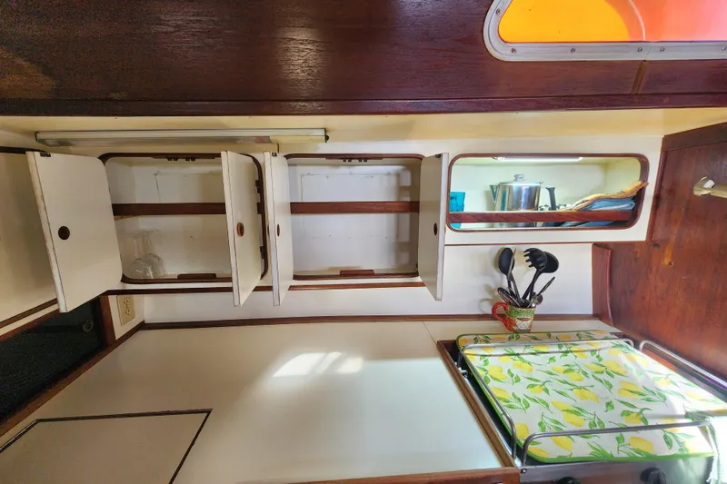 Slide: The Image of Interior of 1981 Guflstar Center Cockpit with open cabinets and kitchen utensils. - 40