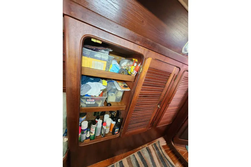 Slide: The Image of Wooden cabinet with assorted supplies inside a 1981 Guflstar Center Cockpit boat. - 44