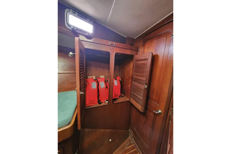 Slide: The Image of Wooden cabinet with life jackets inside a 1981 Guflstar Center Cockpit boat interior. - 52