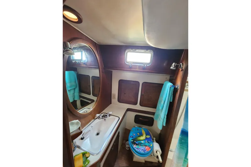 Slide: The Image of 1981 Guflstar Center Cockpit bathroom with sink, mirror, and nautical decor. - 64