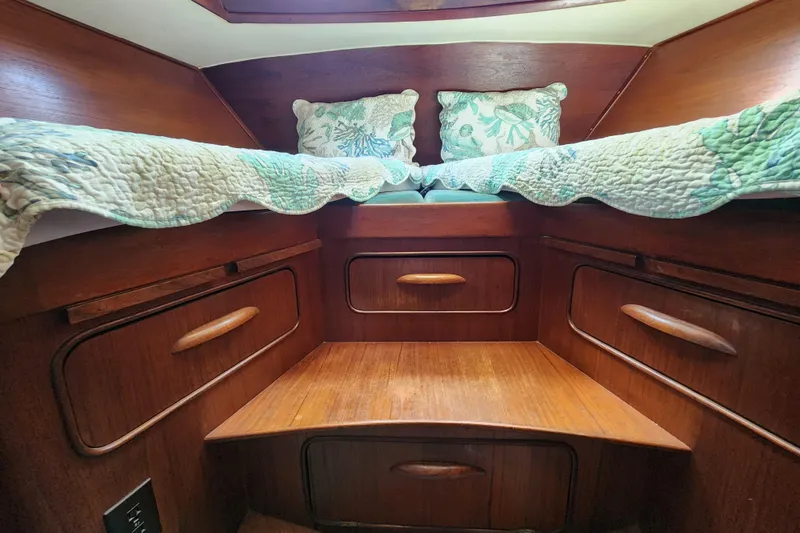 Slide: The Image of Cozy 1981 Guflstar Center Cockpit cabin with wooden drawers and floral bedding. - 65
