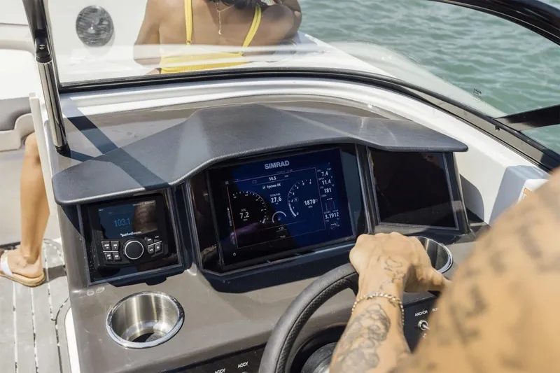 Slide: The Image of 2026 Bayliner VR6 Bowrider OB cockpit with steering wheel and tan seating. - 7