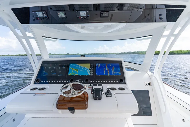 Slide: The Image of 2025 Valhalla Boatworks V-55 helm with advanced navigation displays on open water. - 13