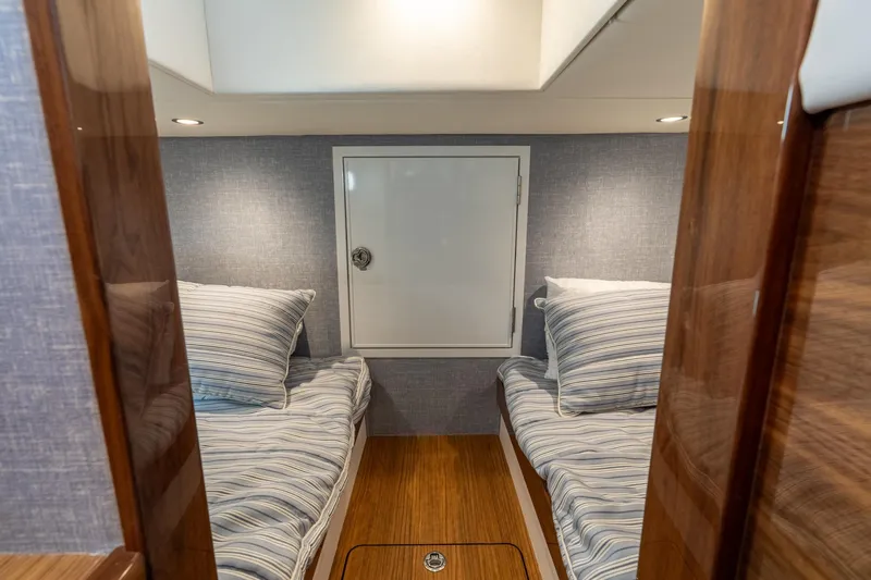 Slide: The Image of 2025 Valhalla Boatworks V-55 cabin with twin beds and wood accents. - 25