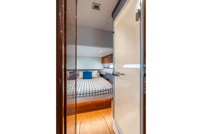 Slide: The Image of 2025 Valhalla V-55 boat interior with cozy bedroom and striped bedding. - 27
