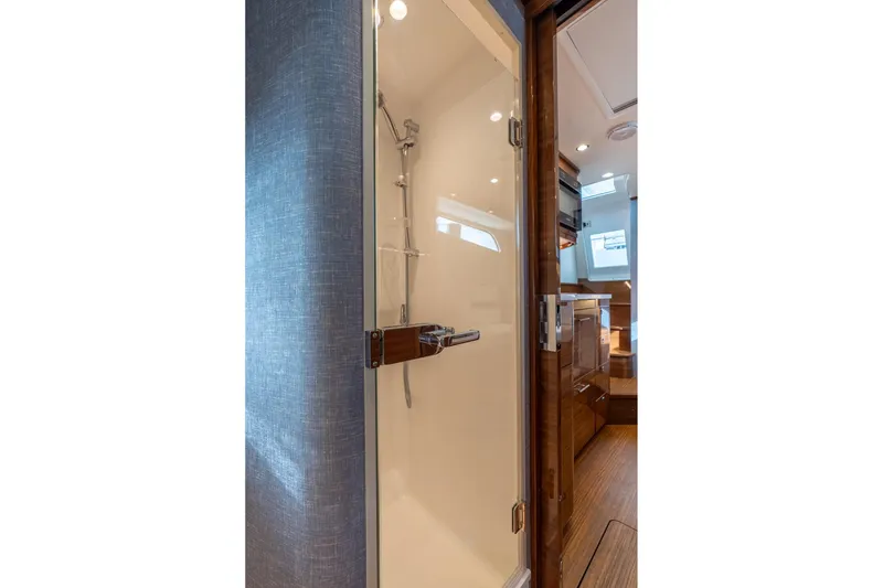 Slide: The Image of 2025 Valhalla Boatworks V-55 interior shower with modern design and wooden accents. - 28