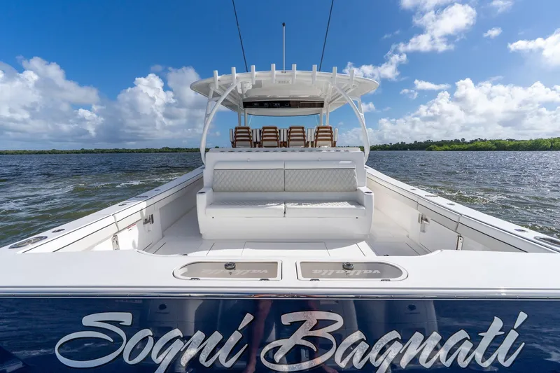 Slide: The Image of 2025 Valhalla Boatworks V-55 on water, clear sky, luxurious seating, "Sogni Bagnati" name visible. - 41