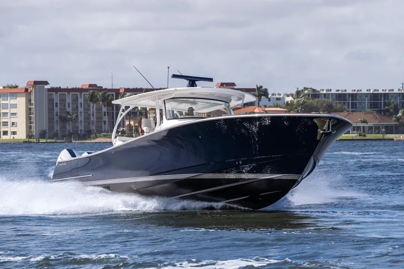 Slide: The Image of 2025 Valhalla Boatworks V-55 cruising on water near coastal buildings. - 9