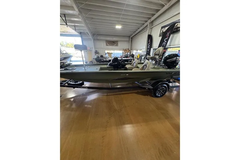 Slide: The Image of 2026 Vexus AVX181 DEFENDER boat displayed in a showroom with wooden flooring. - 4