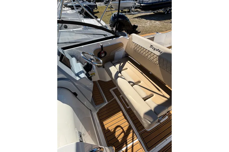 Slide: The Image of 2026 Trophy T22SC boat interior with beige seating and wooden flooring. - 11
