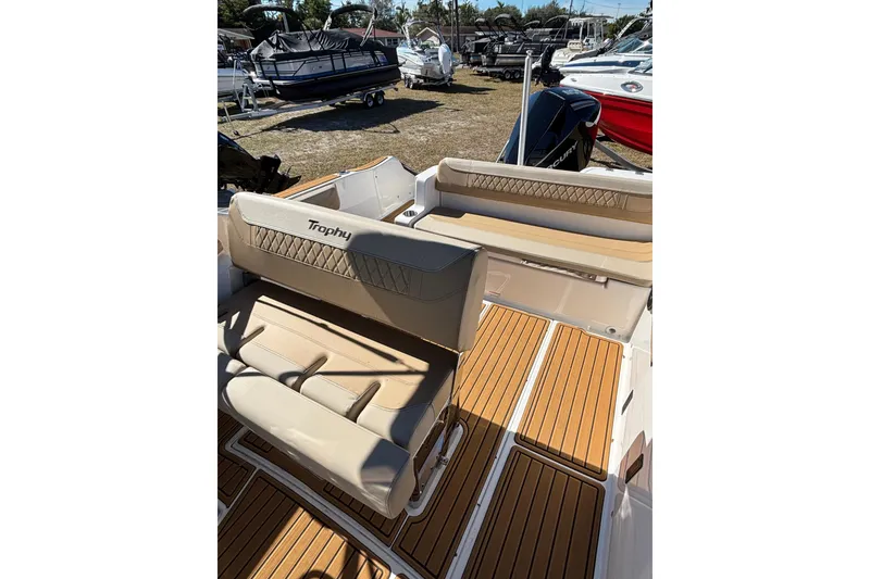 Slide: The Image of 2026 Trophy T22SC boat interior with tan seating and wood-style flooring. - 13
