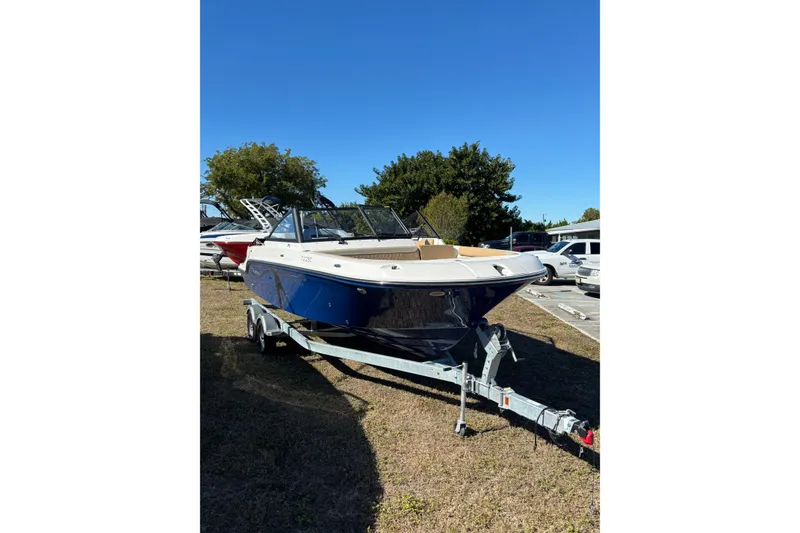 Slide: The Image of 2026 Trophy T22SC boat on trailer, parked outdoors under clear blue sky. - 5