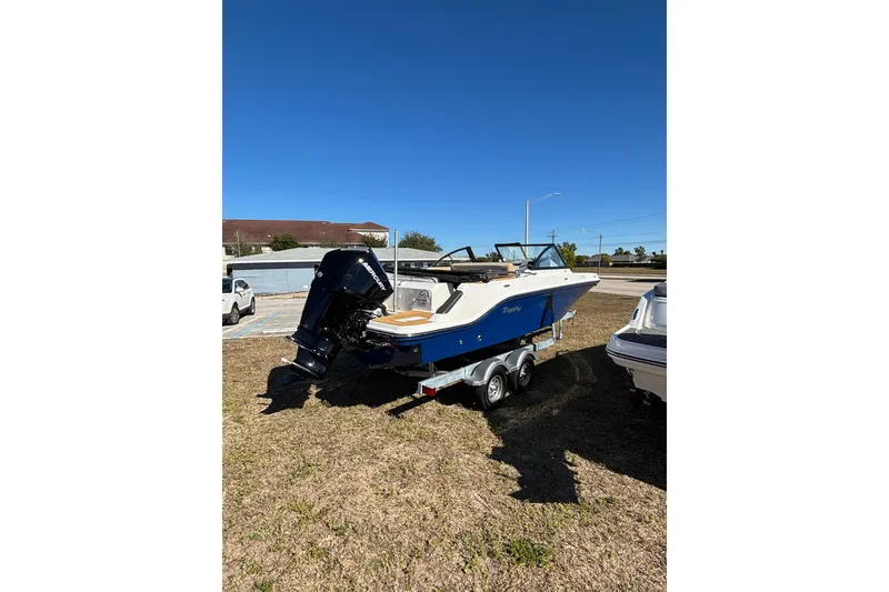 Slide: The Image of 2026 Trophy T22SC boat on trailer, parked outdoors under clear blue sky. - 6