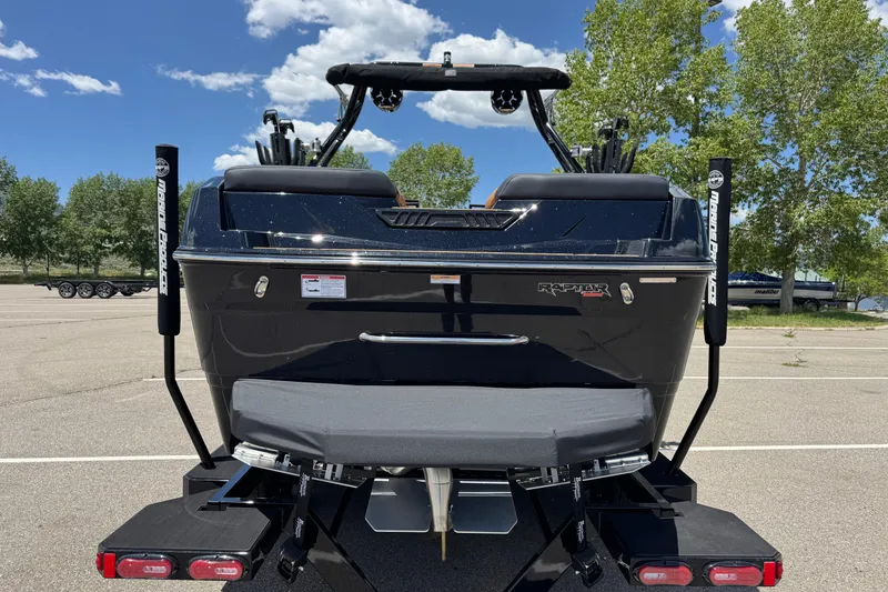 Slide: The Image of 2025 Moomba Tykon boat rear view in parking lot, showcasing sleek design and Raptor engine. - 3