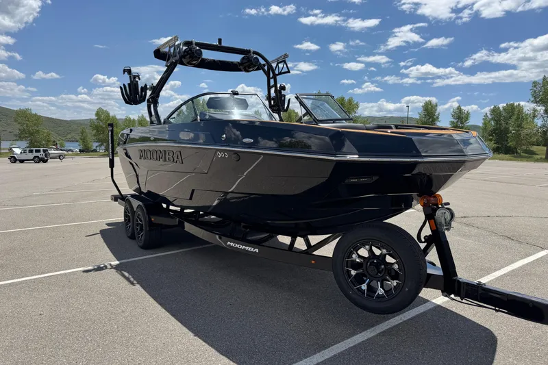 Slide: The Image of 2025 Moomba Tykon boat on trailer in sunny parking lot. - 4