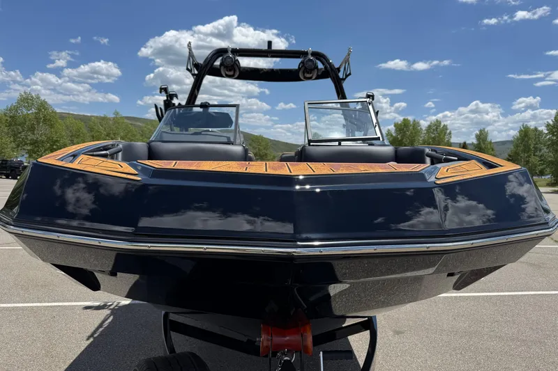 Slide: The Image of 2025 Moomba Tykon boat with sleek design, parked under a clear blue sky. - 5